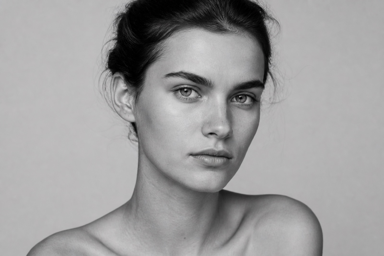 Black-and-white editorial close-up portrait of a female model
