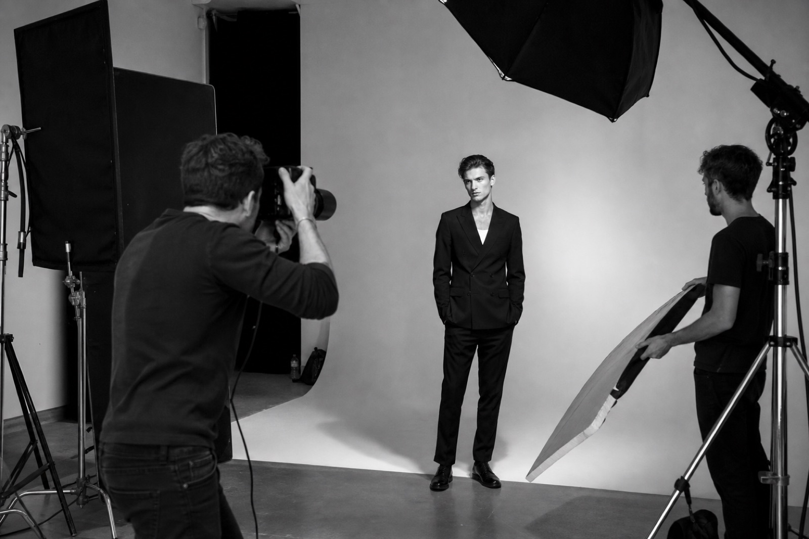 Black-and-white studio photoshoot with a photographer, model and assistant at work